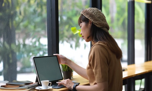 a women looking toward and working on a laptop