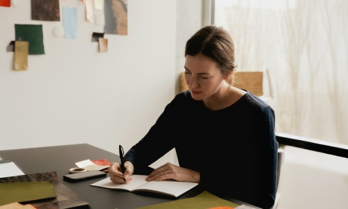 a woman writing on a desk